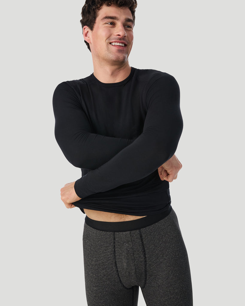 A man wearing Grey Stripe FlexStripe Pant shown in a front view pose while lifting his T-shirt slightly