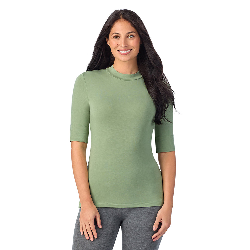 Hedge Green; Model is wearing size S. She is 5'8.5", Bust 32", Waist 25", Hips 36".@A lady wearing a green elbow sleeve mock neck.