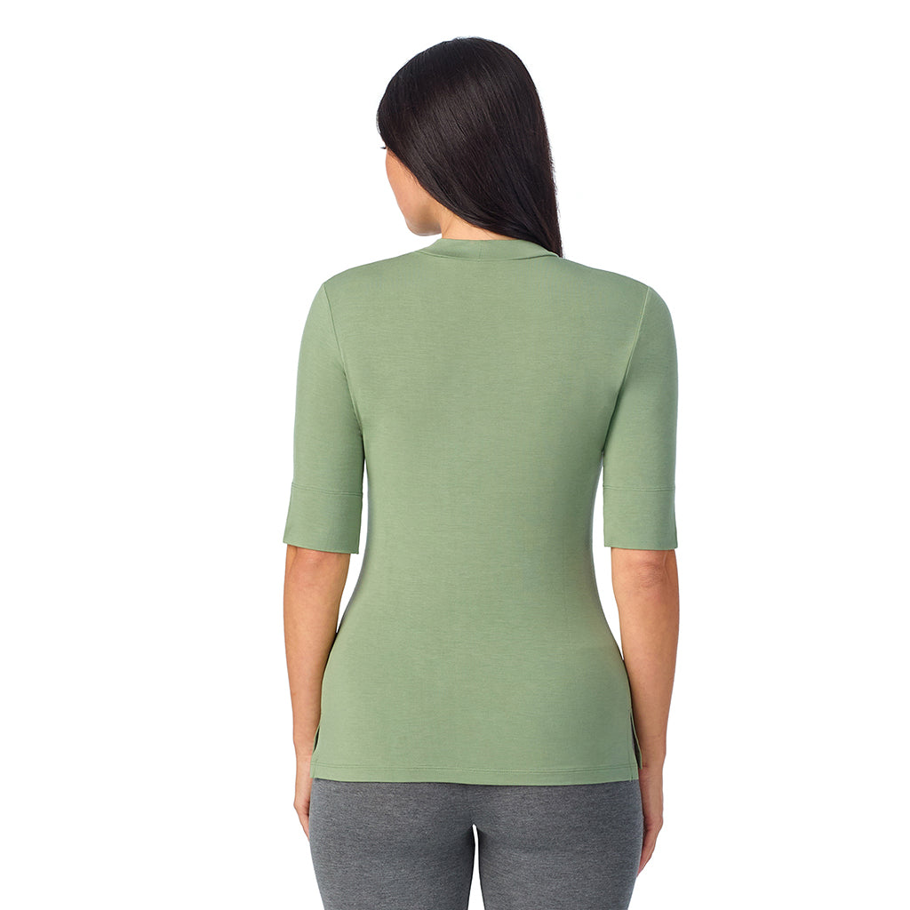 Hedge Green; Model is wearing size S. She is 5'8.5", Bust 32", Waist 25", Hips 36".@A lady wearing a green elbow sleeve mock neck.