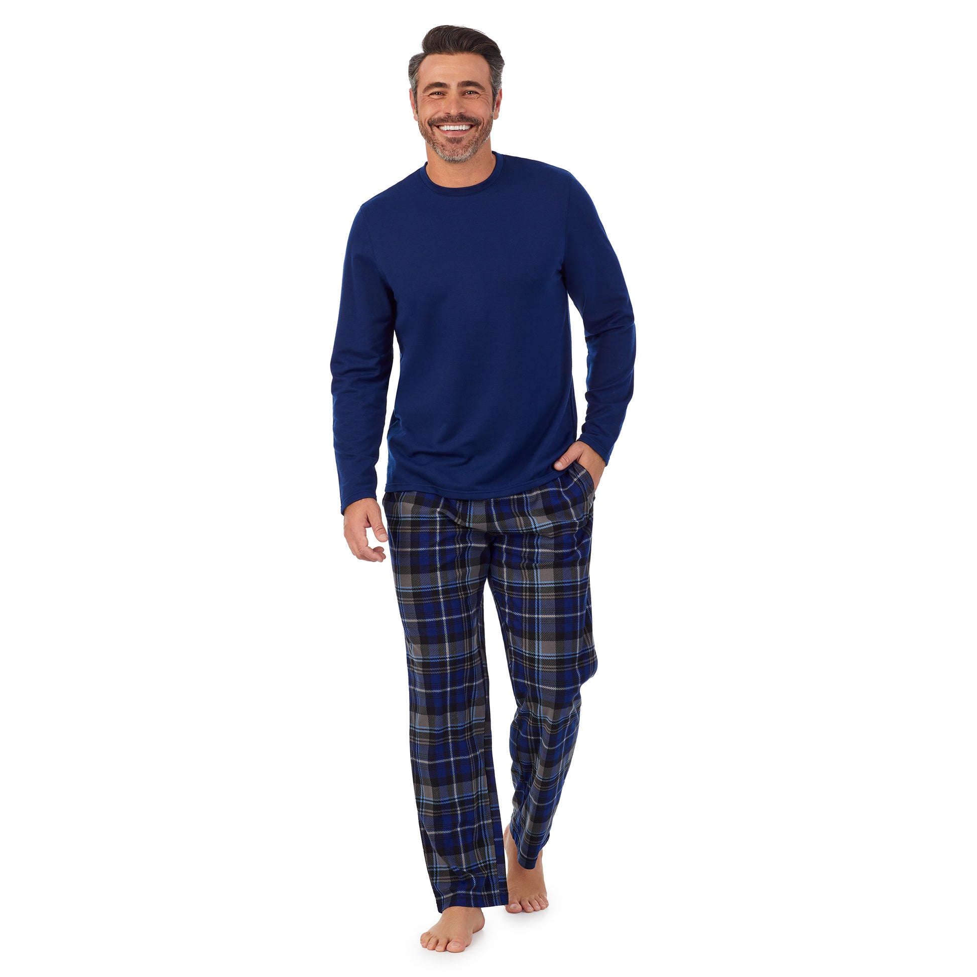 A man wearing blue Mens Cozy Lodge Long Sleeve Crew and blue grey plaid Pajama Pant 2-pc Set