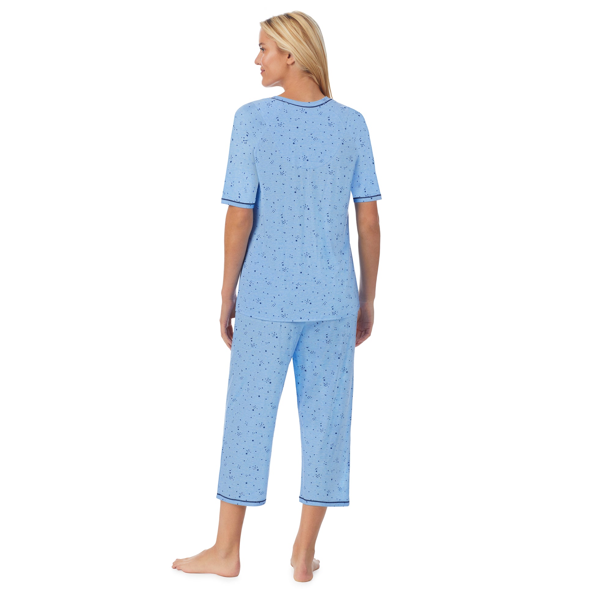 A lady wearingCuddl Smart Elbow Sleeve Top with Cropped Pant Pajama Set with Navy Celestial print