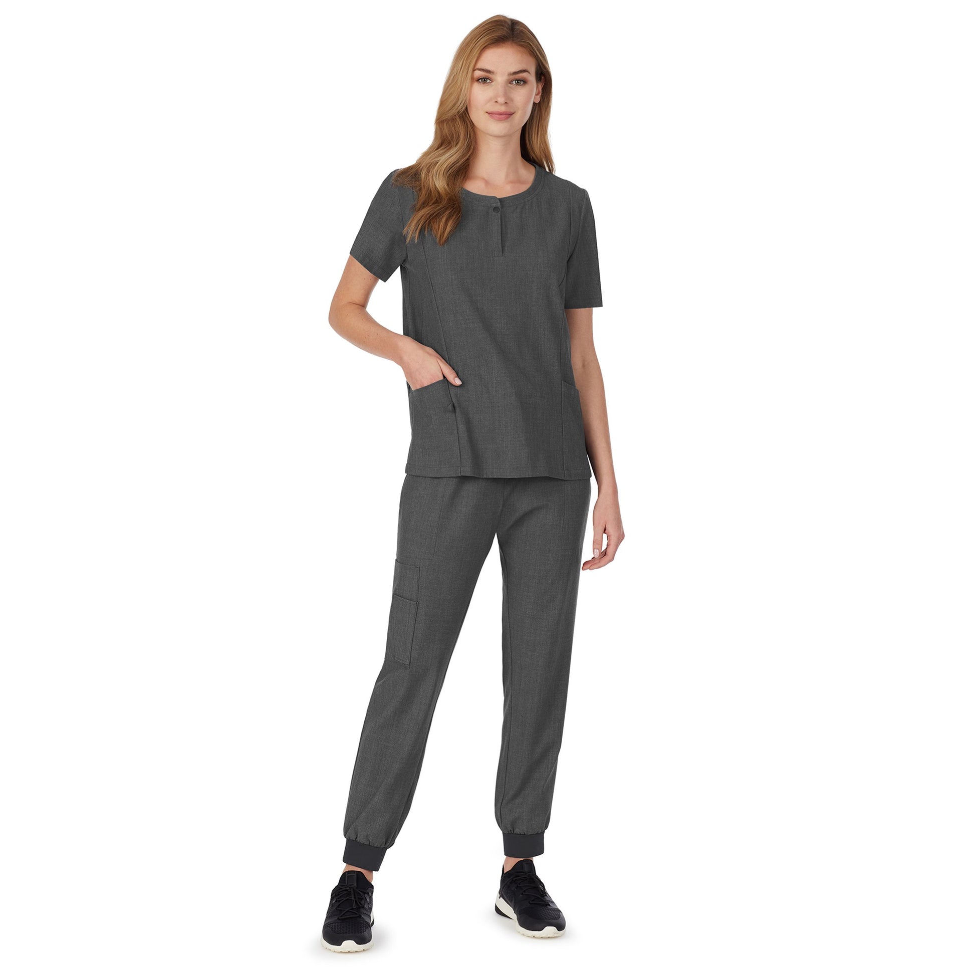 A lady wearing charcoal heather scrub henley neck top with side pockets petite.