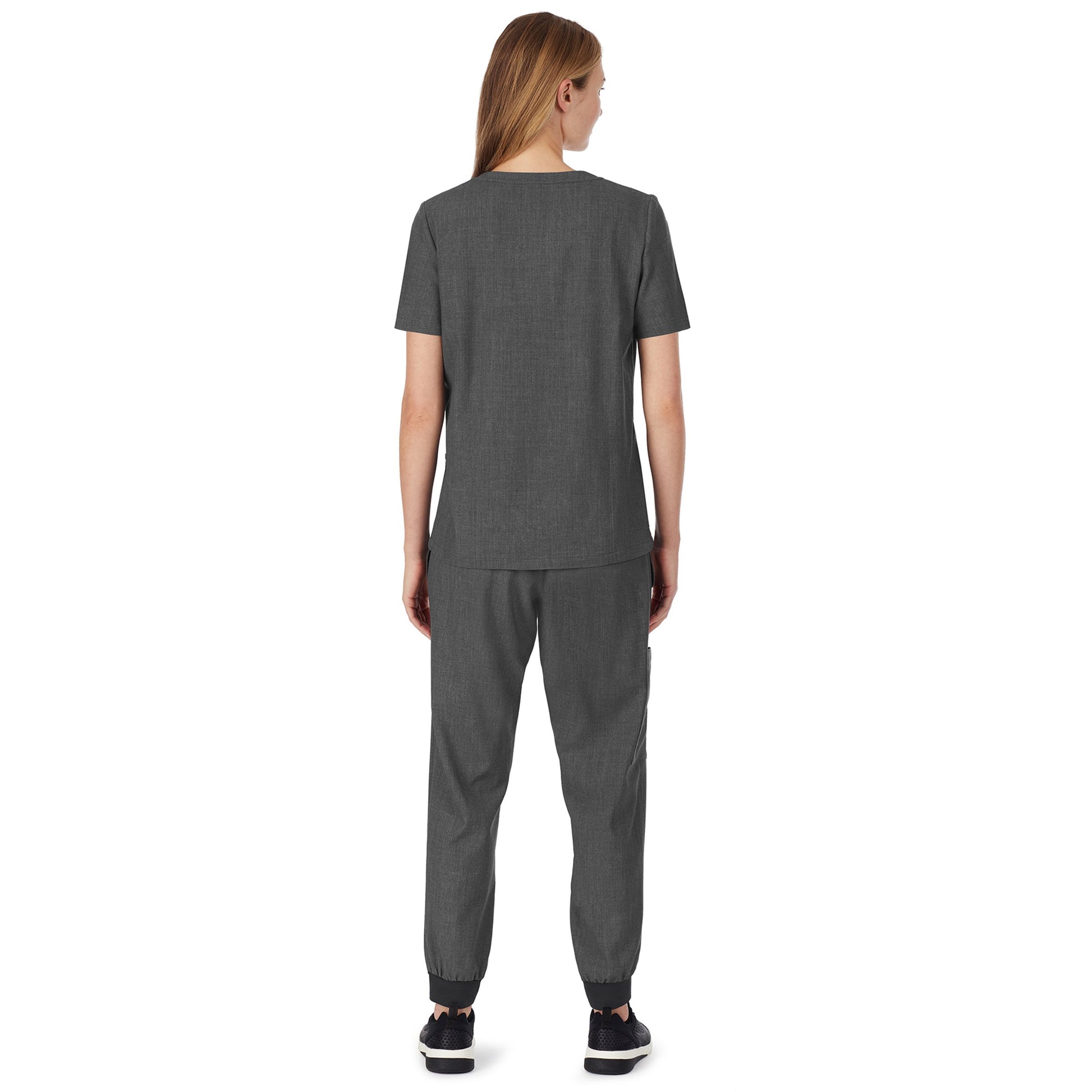 A lady wearing charcoal heather scrub henley neck top with side pockets petite.