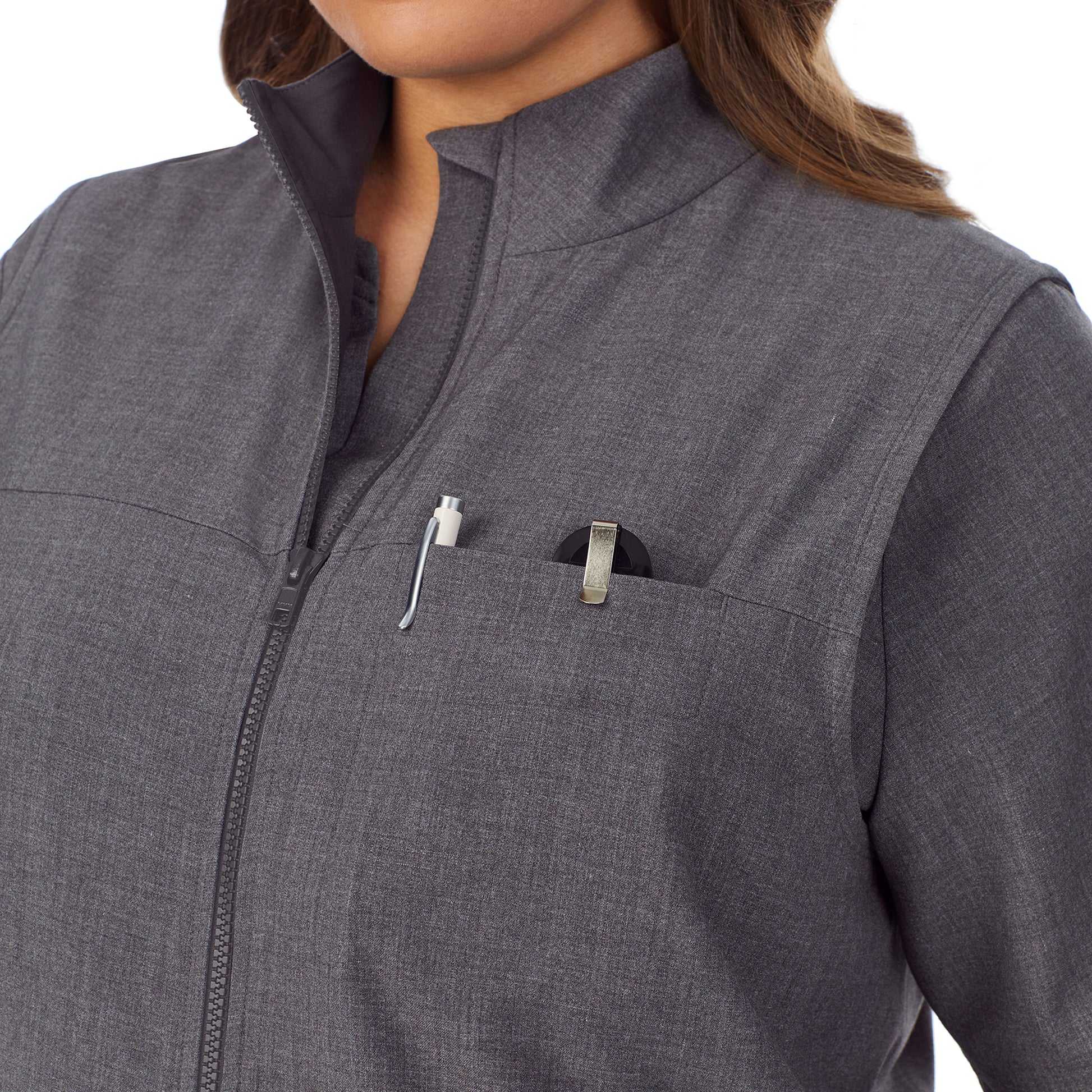 A lady wearing charcoal heather scrub vest plus.