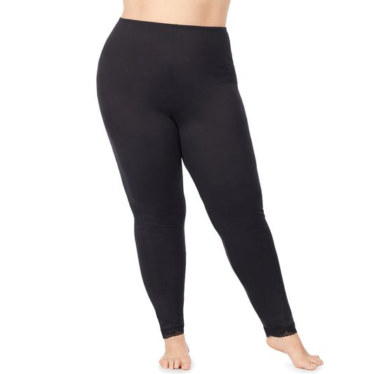 A lady wearing a black lace edge legging plus.