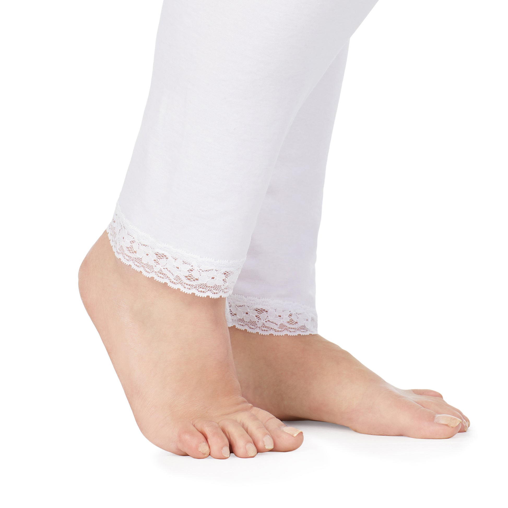 A lady wearing a white lace edge legging plus.