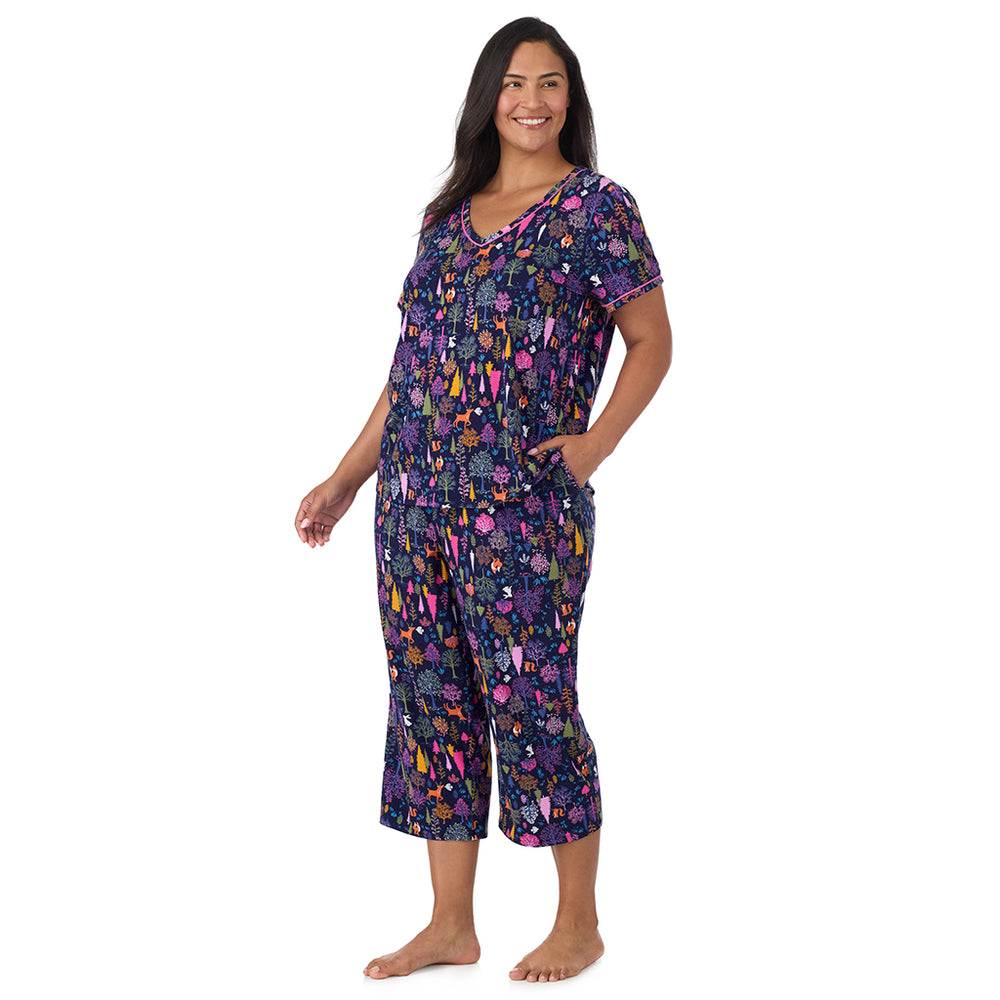 A lady wearing Cotton-Blend Short Sleeve Top with Cropped Pant Pajama Set PLUS in Navy Woodland looking side