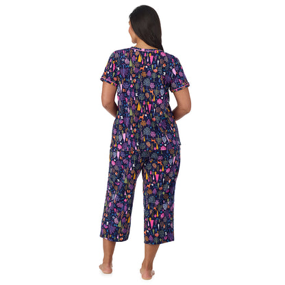 A lady wearing plus size Cotton-Blend Short Sleeve Top with Cropped Pant Pajama Set PLUS Navy Woodland back view