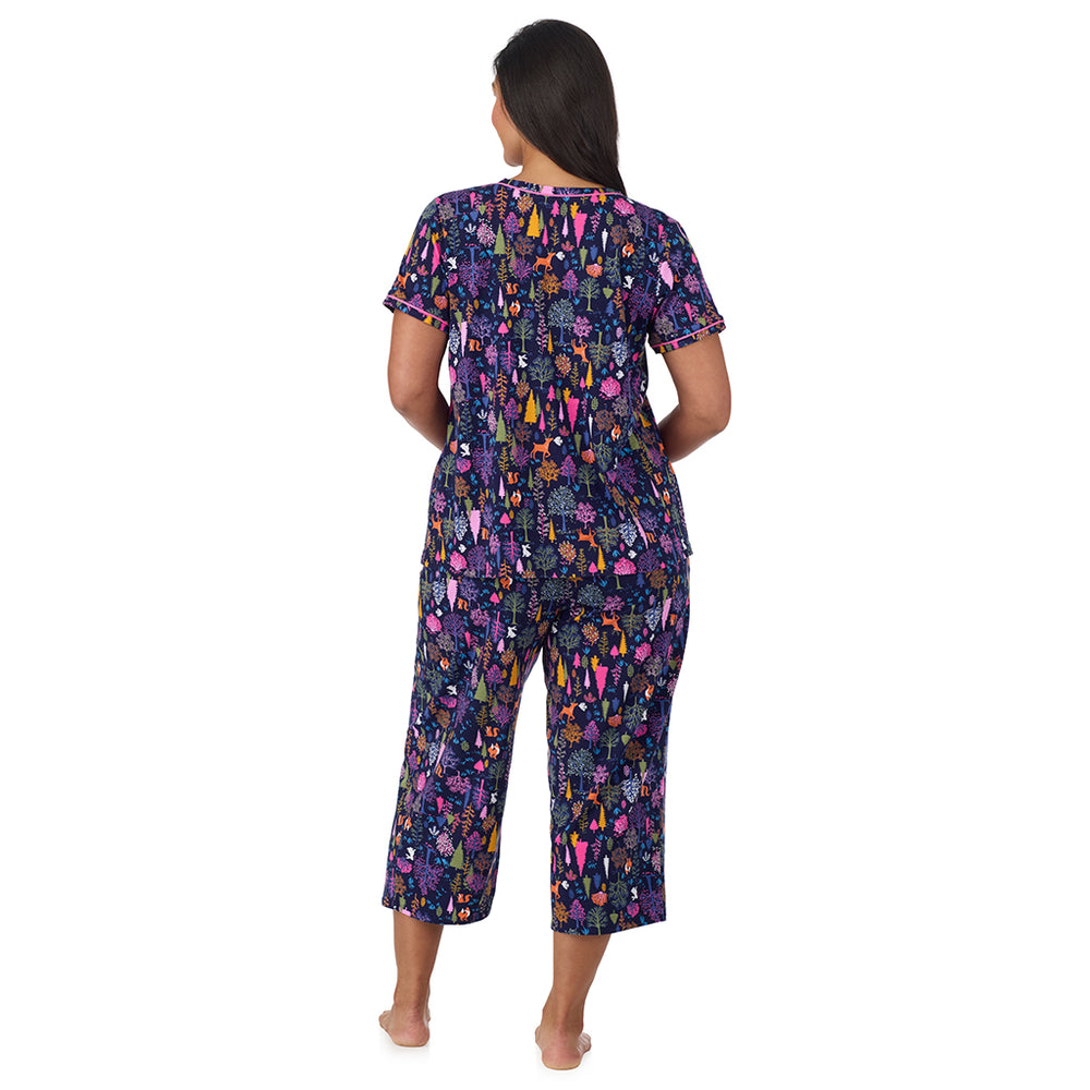 A lady wearing Cotton-Blend Short Sleeve Top with Cropped Pant Pajama Set PLUS in Navy Woodland back view