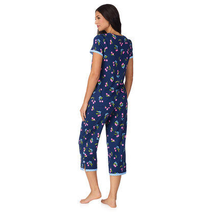 A lady wearing Cotton-Blend Short Sleeve Top with Cropped Pant 2-Pc Pajama Set in Navy Cherry Bow