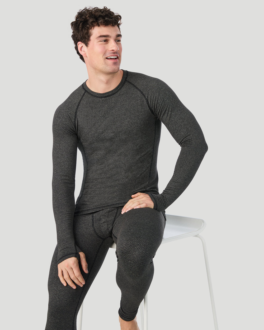 A man wearing Grey Stripe FlexStripe Long Sleeve Crew in a front sitting pose while looking to the side