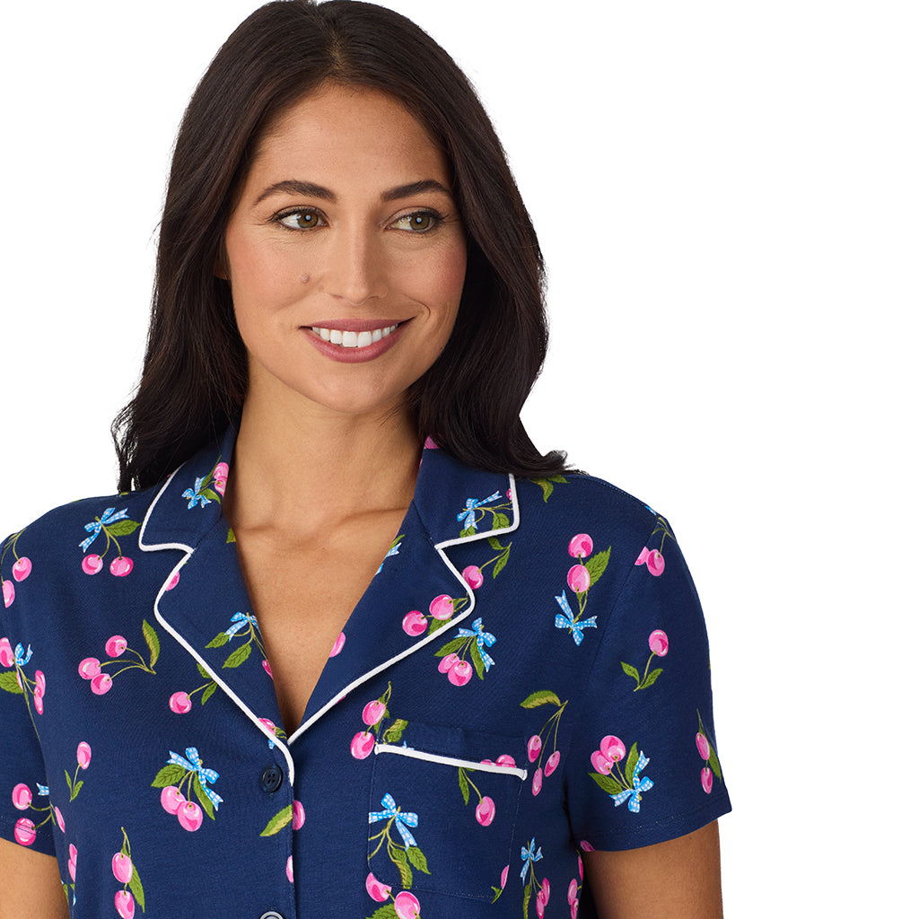 Navy Cherry Bow; Model is wearing size S. She is 5'8.5", Bust 32", Waist 25", Hips 36". @A lady wearing Cotton-Blend Short Sleeve Notch Collar with Cropped Pant 2-Pc Pajama Set in Navy Cherry Bow