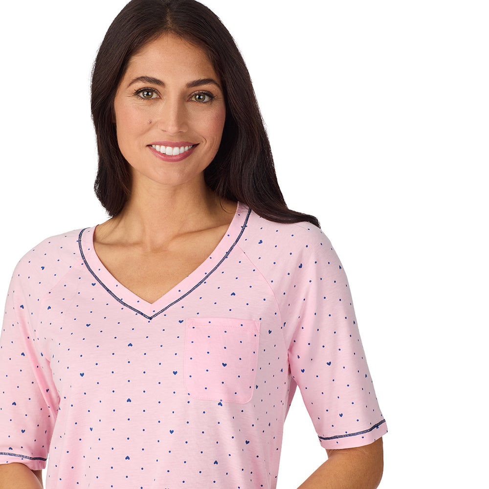A lady wearing Cuddl Smart Elbow Sleeve Top with Cropped Pant Pajama Set with Pink Bow print