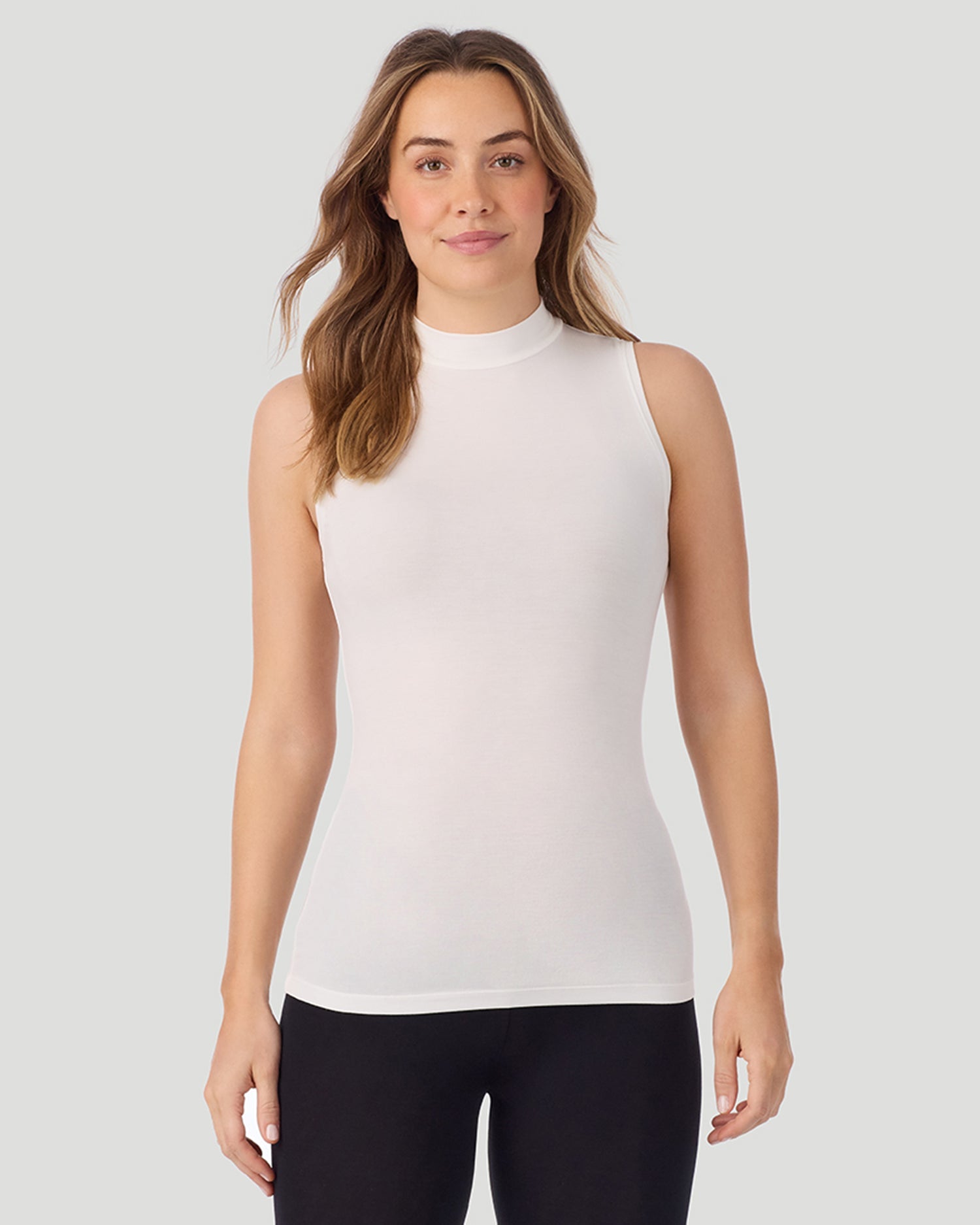 A lady wearing Softwear With Stretch Mock Neck Tank in ivory shown in a front view pose