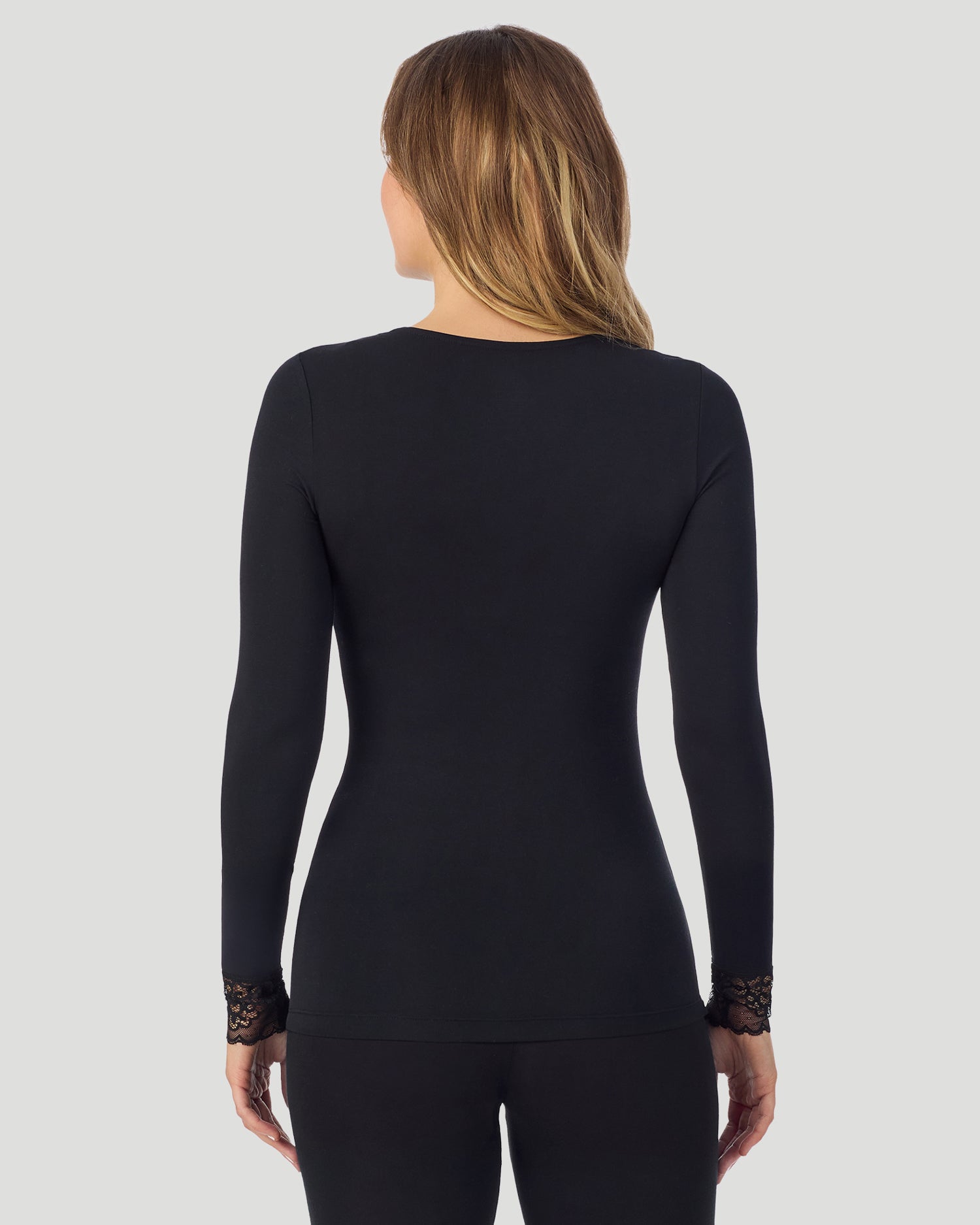 A lady wearing Softwear With Stretch Long Sleeve V-Neck With Lace in black shown in a back view pose