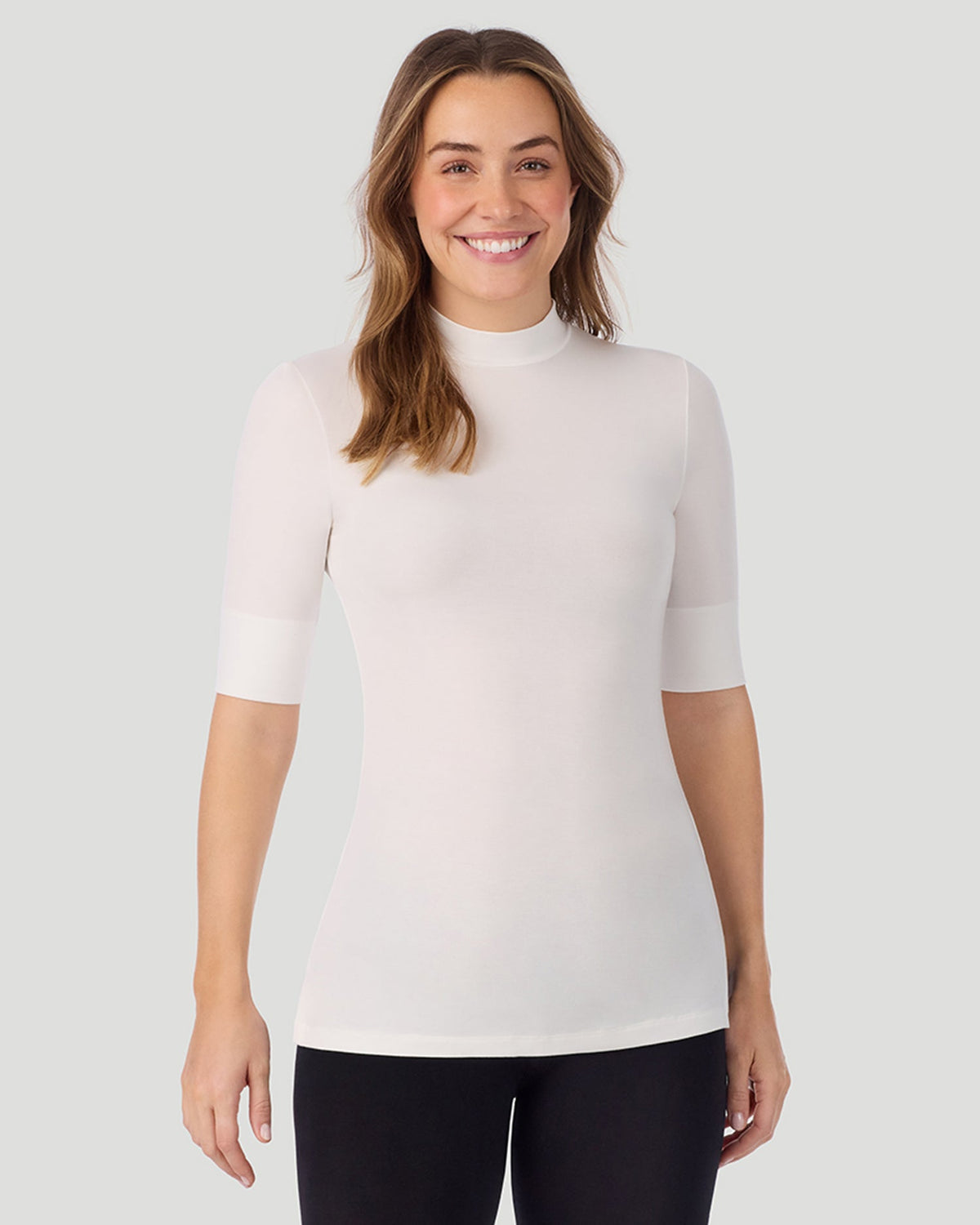 A lady wearing Softwear With Stretch Elbow Sleeve Mock Neck in ivory shown in a front view pose