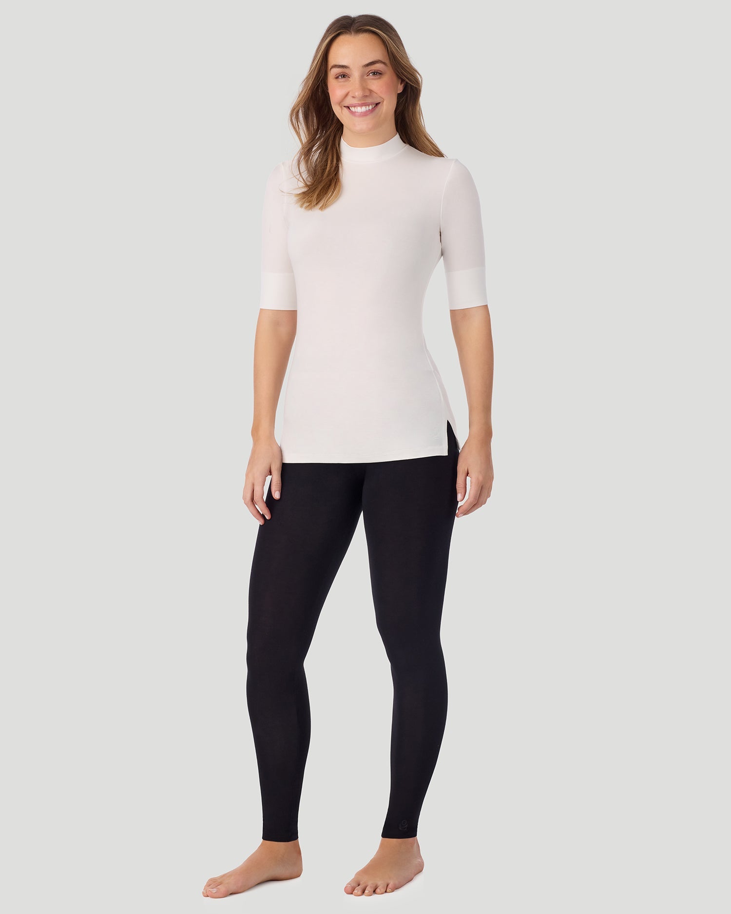 A lady wearing Softwear With Stretch Elbow Sleeve Mock Neck in ivory shown in a front view standing pose
