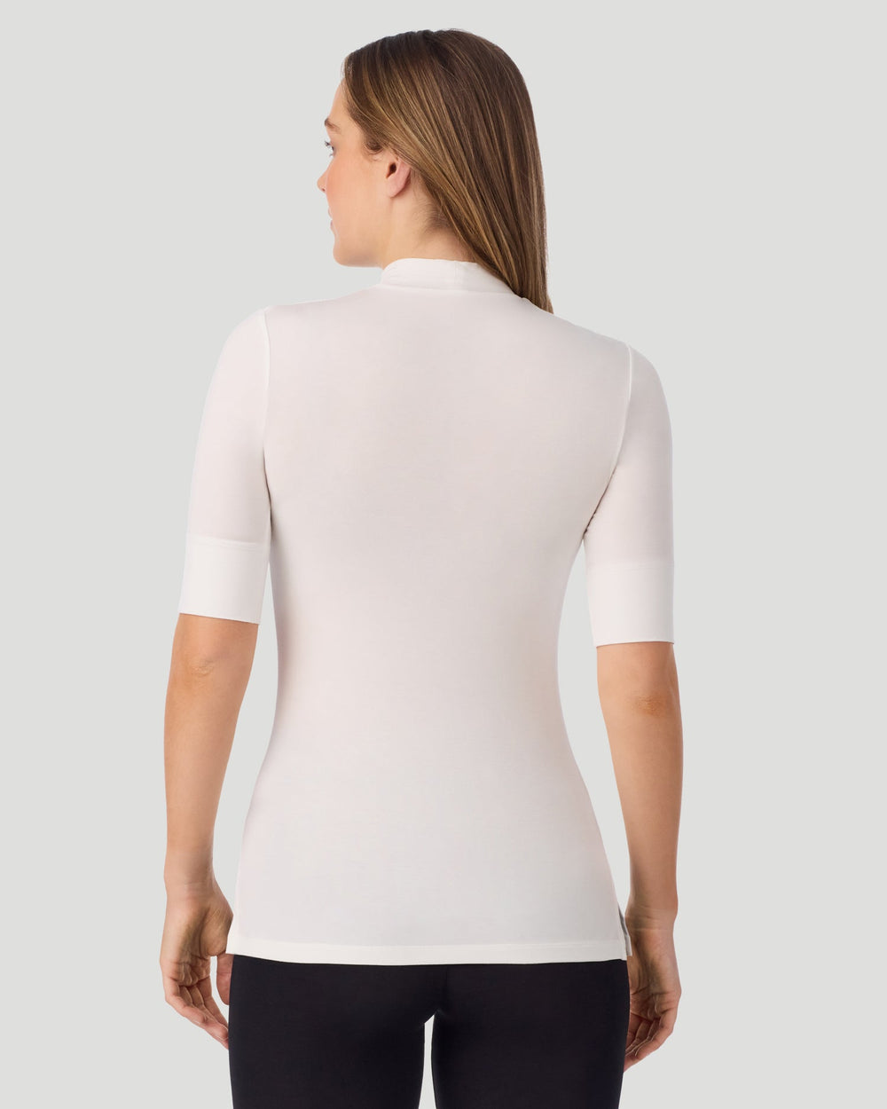 A lady wearing Softwear With Stretch Elbow Sleeve Mock Neck in ivory shown in a back view pose