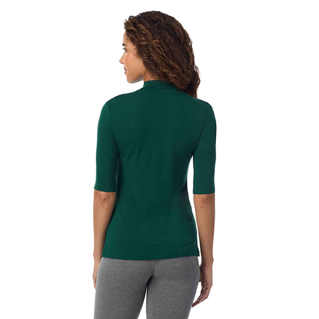 A lady wearing a evergreen elbow sleeve mock neck.