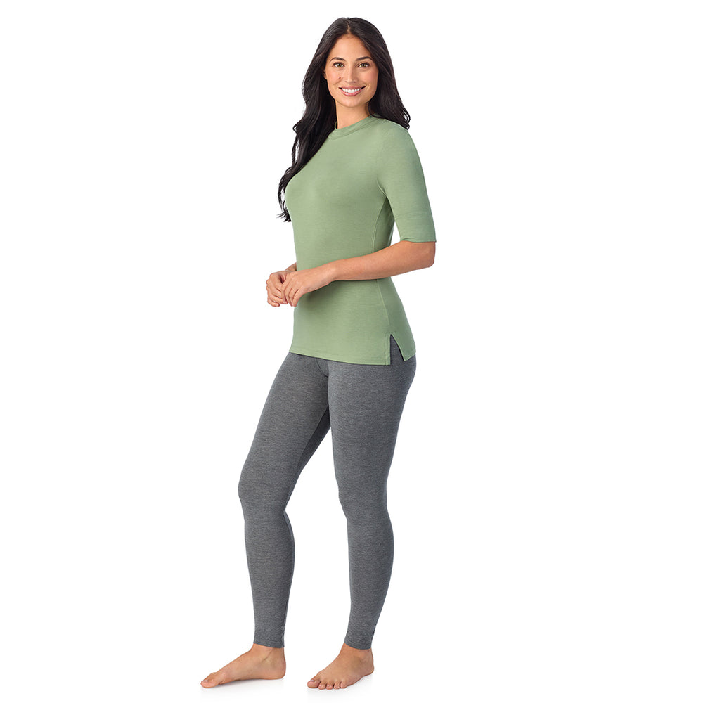 A lady wearing a green elbow sleeve mock neck.