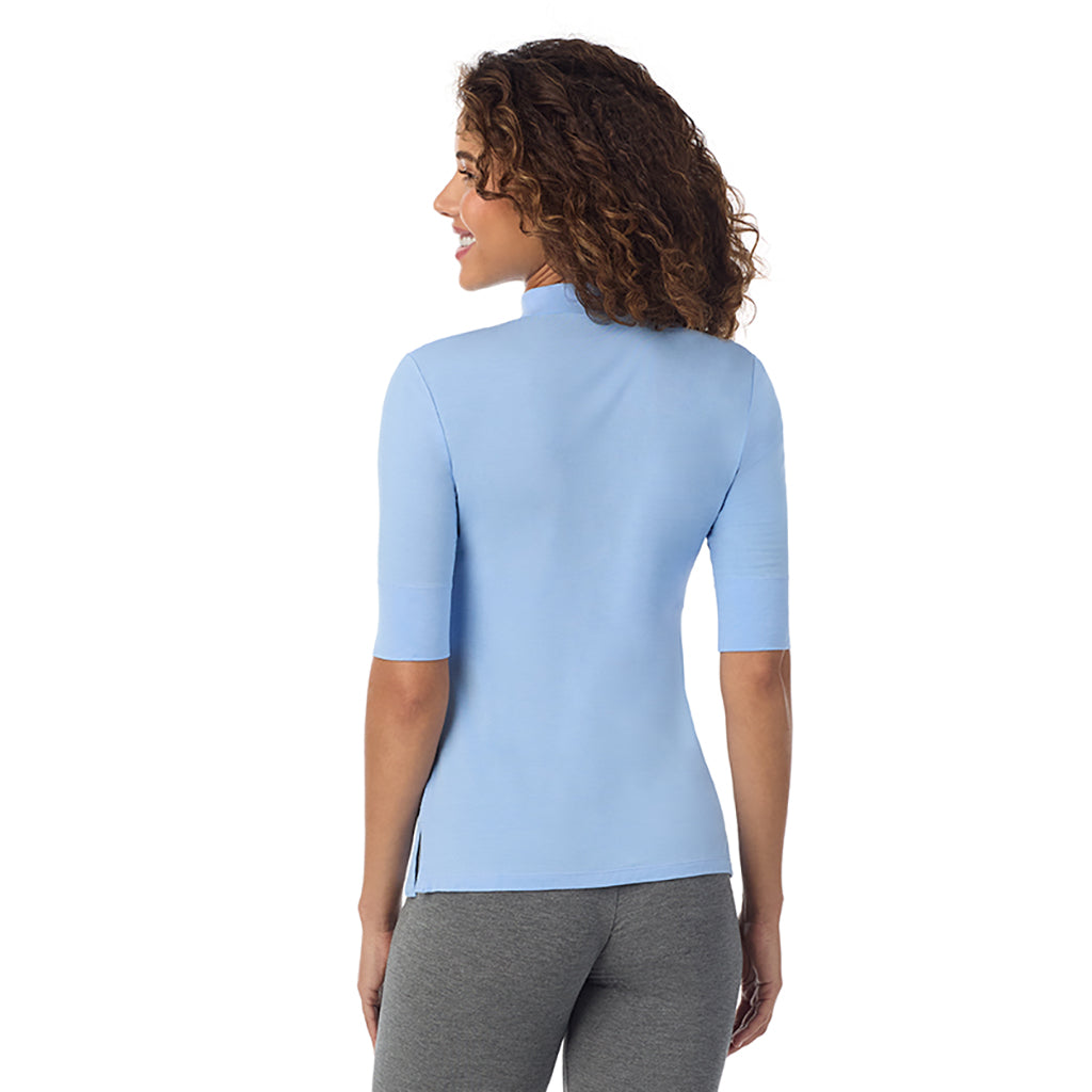 Vista Blue; Model is wearing size S. Model is wearing size S. She is 5’9”, Bust 34”, Waist 23”, Hips 35”. @A lady wearing a vista blue elbow sleeve mock neck.