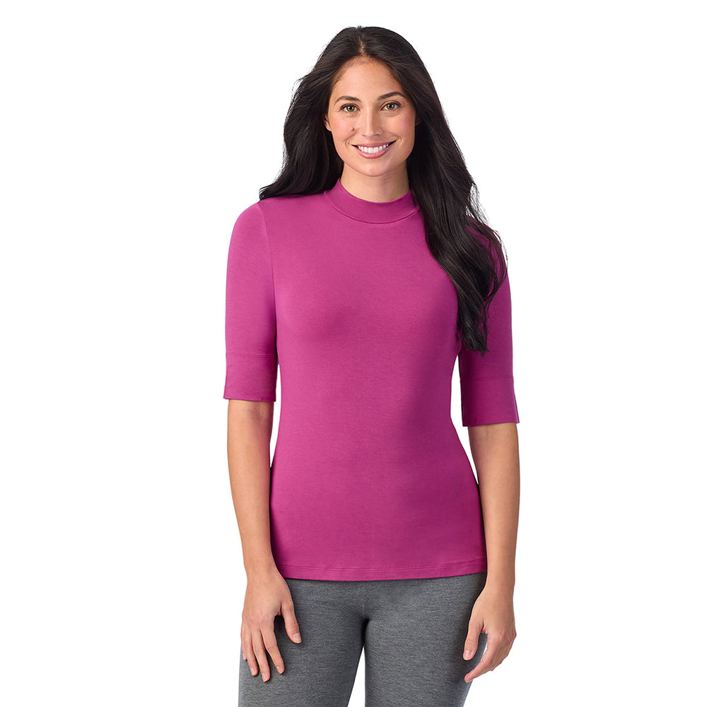 A lady wearing a pink elbow sleeve mock neck.