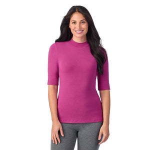 A lady wearing a pink elbow sleeve mock neck.
