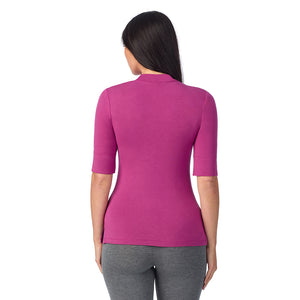 A lady wearing a pink elbow sleeve mock neck.