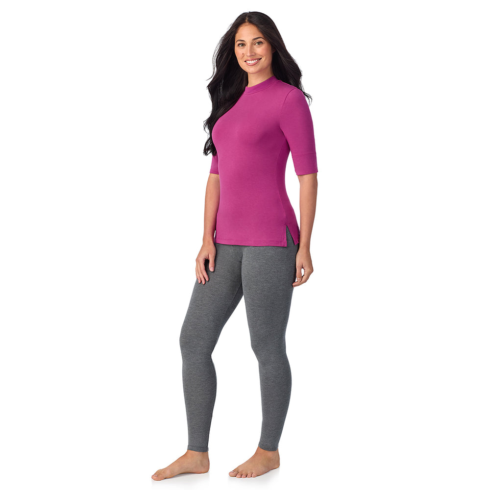 A lady wearing a pink elbow sleeve mock neck.