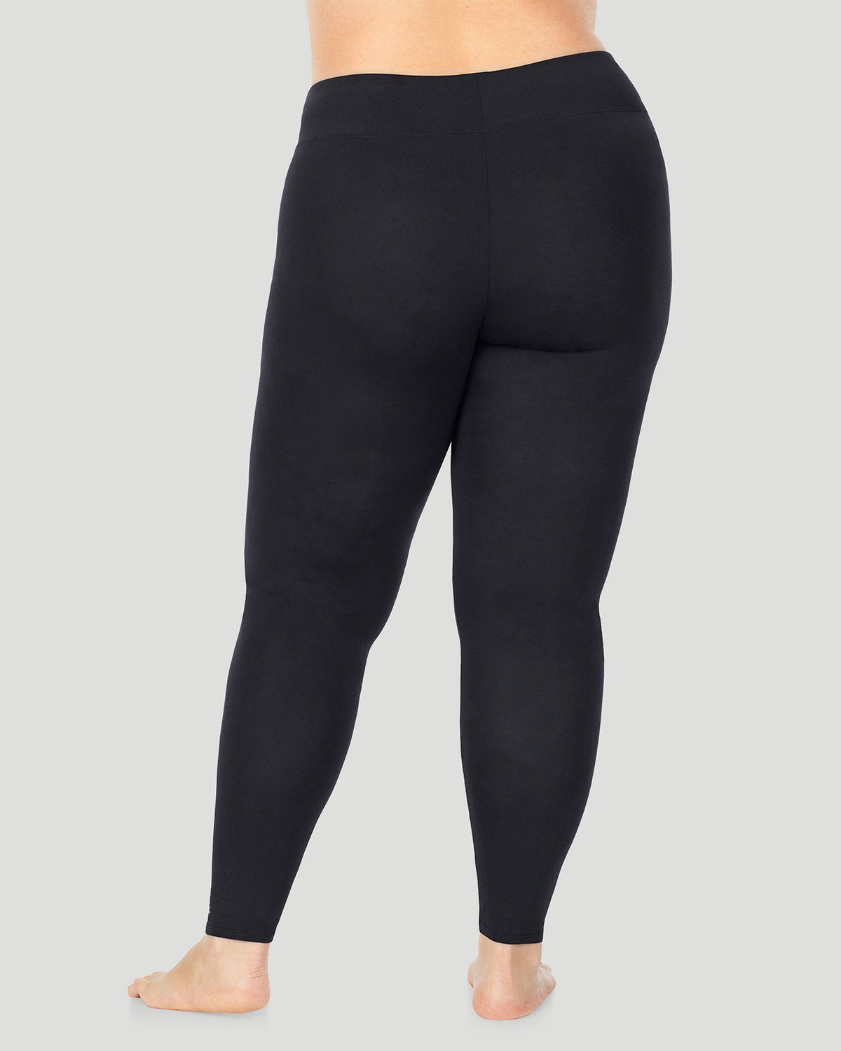 A plus size lady wearing Softwear With Stretch High Waist Legging PLUS in black in a back view pose