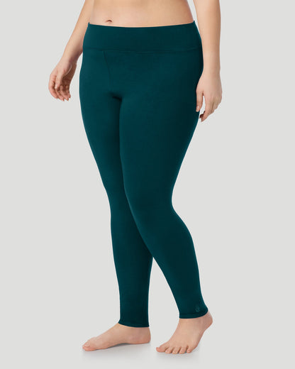 A plus size lady wearing Softwear With Stretch High Waist Legging PLUS in deep emerald in a front view side angle pose