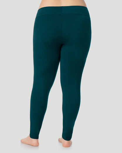 A plus size lady wearing Softwear With Stretch High Waist Legging PLUS in deep emerald in a back view pose