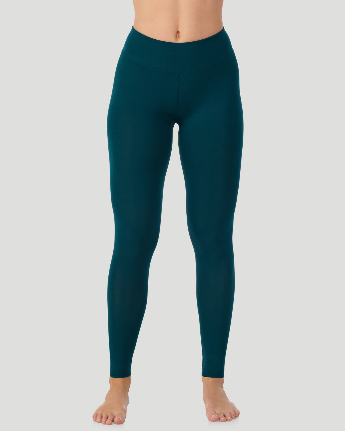 A lady wearing Softwear With Stretch High Waist Legging in deep emerald posing in a clean front view standing position