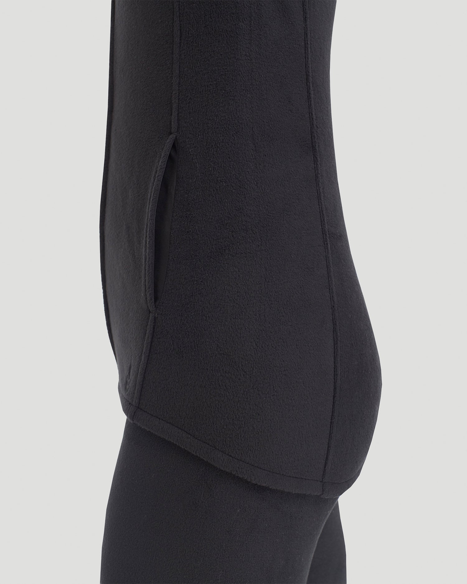 A lady wearing Fleecewear with Stretch Vest in Black back view back view