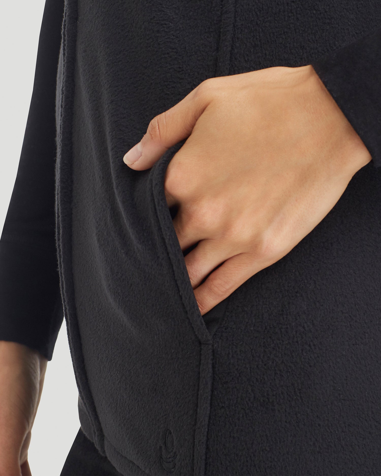 A lady wearing Fleecewear with Stretch Vest in Black back view back view