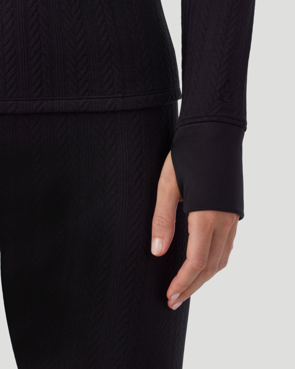  A lady wearing Cozy Cable Long Sleeve Quarter Zip Top in black closer look at hand