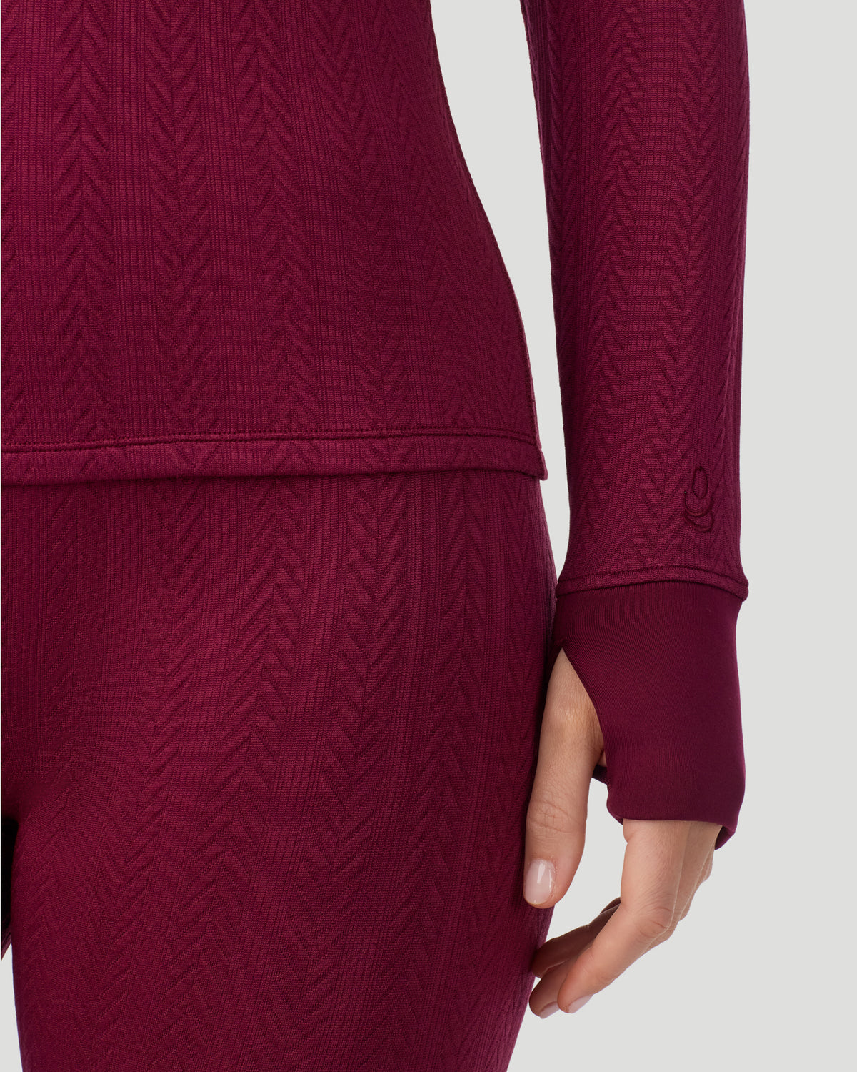 Bordeaux; Model is wearing a size S. She is 5’11.5”, Bust 34”, Waist 27”, Hips 38.5”. @ A lady wearing Cozy Cable Long Sleeve Quarter Zip Top in Bordeaux closer look at hand