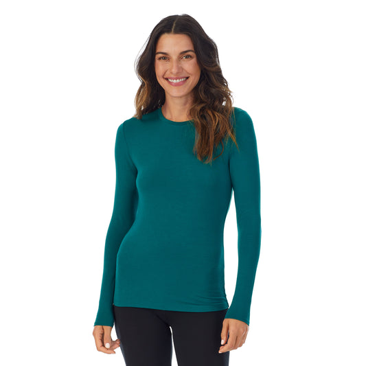 A lady wearing a Teal Lagoon long sleeve stretch crew.