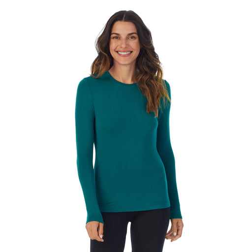 Teal Lagoon; Model is wearing size S. She is 5’9”, Bust 34”, Waist 25.5”, Hips 36.5”. @A lady wearing a Teal Lagoon long sleeve stretch crew.