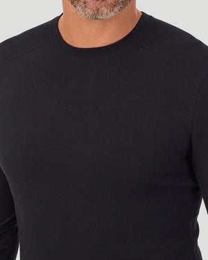 A man wearing a black long sleeve crew