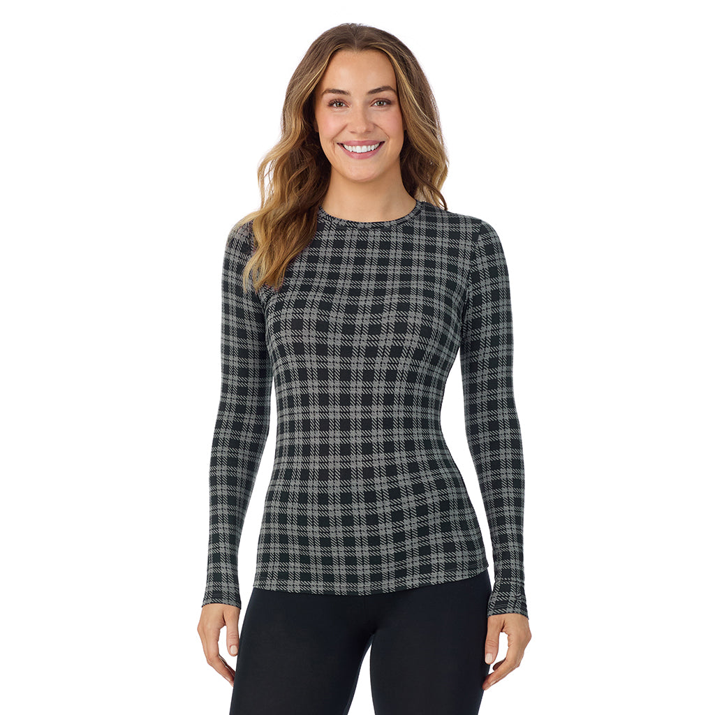 A lady wearing a charcoal/black plaid long sleeve stretch crew.