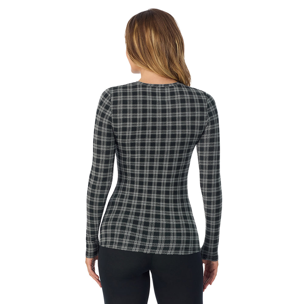 A lady wearing a charcoal/black plaid long sleeve stretch crew.