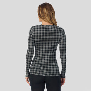 A lady wearing a charcoal/black plaid long sleeve stretch crew.