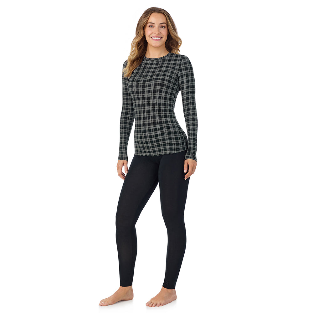 A lady wearing a charcoal/black plaid long sleeve stretch crew.