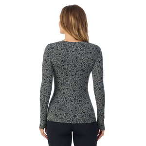 A lady wearing a charcoal paisley long sleeve stretch crew.