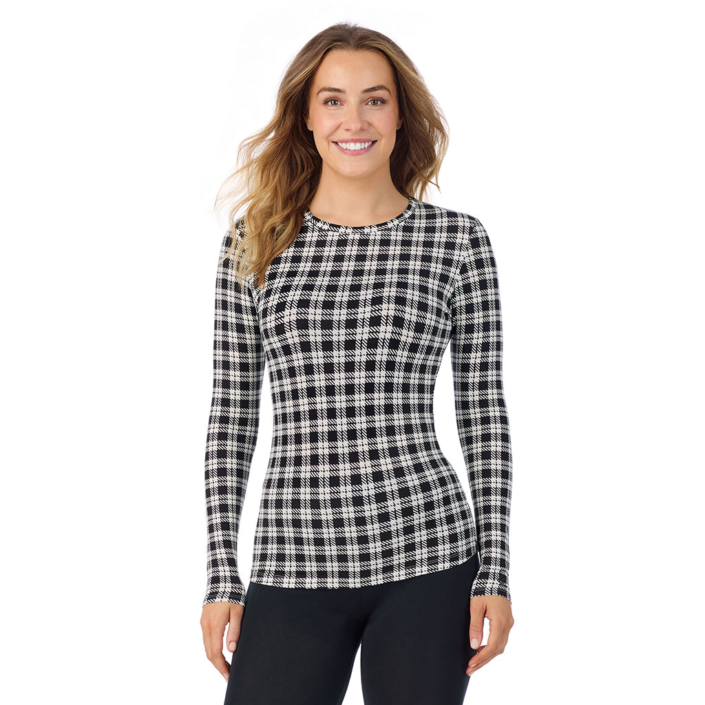 A lady wearing a ivory/black plaid long sleeve stretch crew.