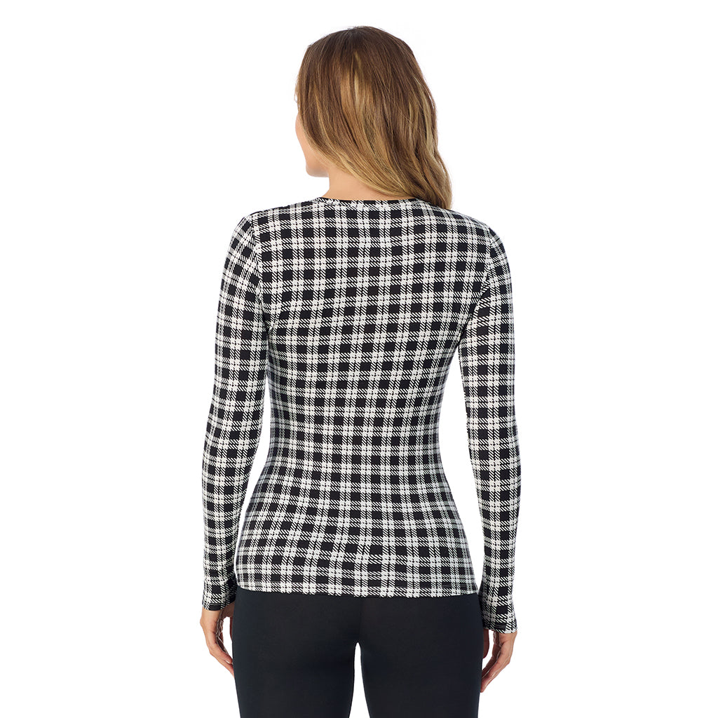 A lady wearing a ivory/black plaid long sleeve stretch crew.