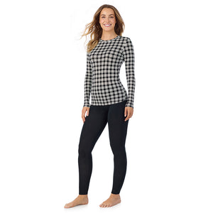 A lady wearing a ivory/black plaid long sleeve stretch crew.