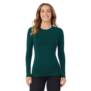 A lady wearing a dark pine long sleeve stretch crew tall.