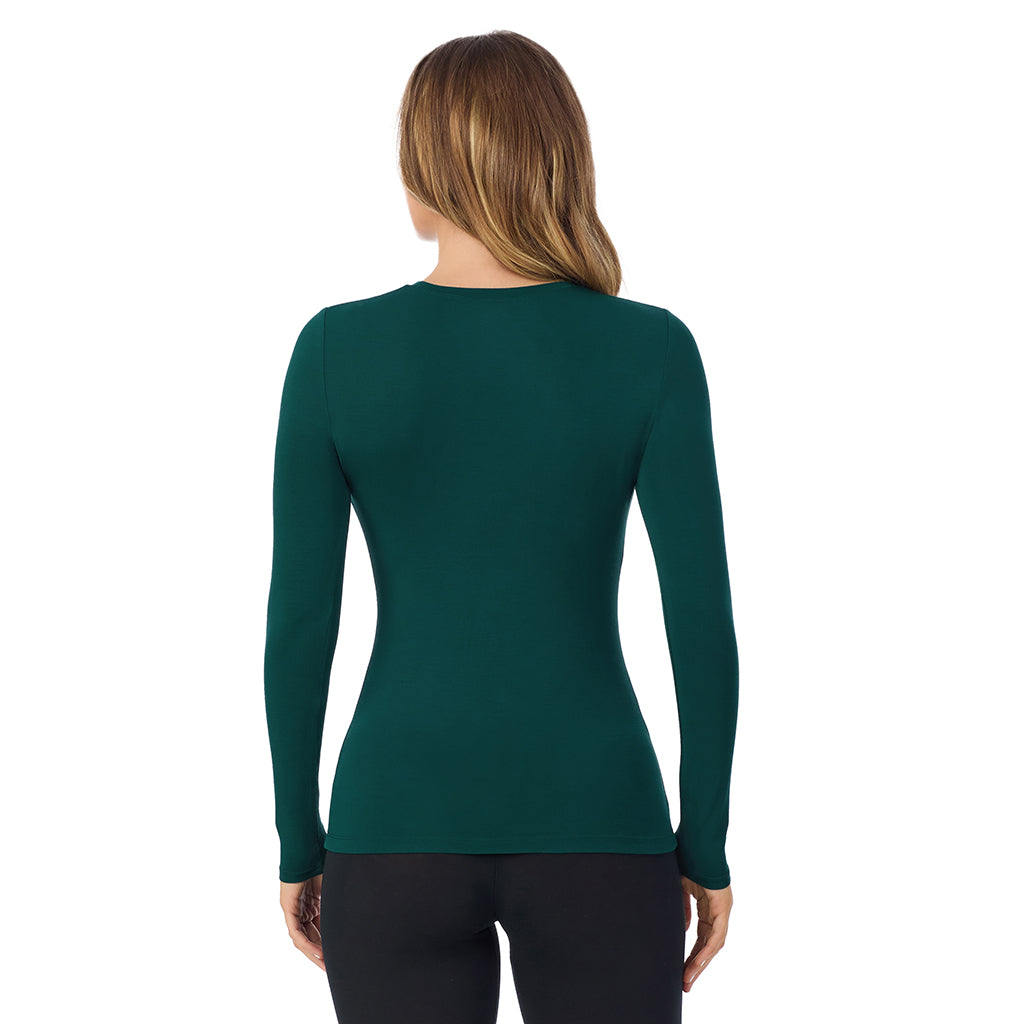 A lady wearing a dark pine long sleeve stretch crew tall.